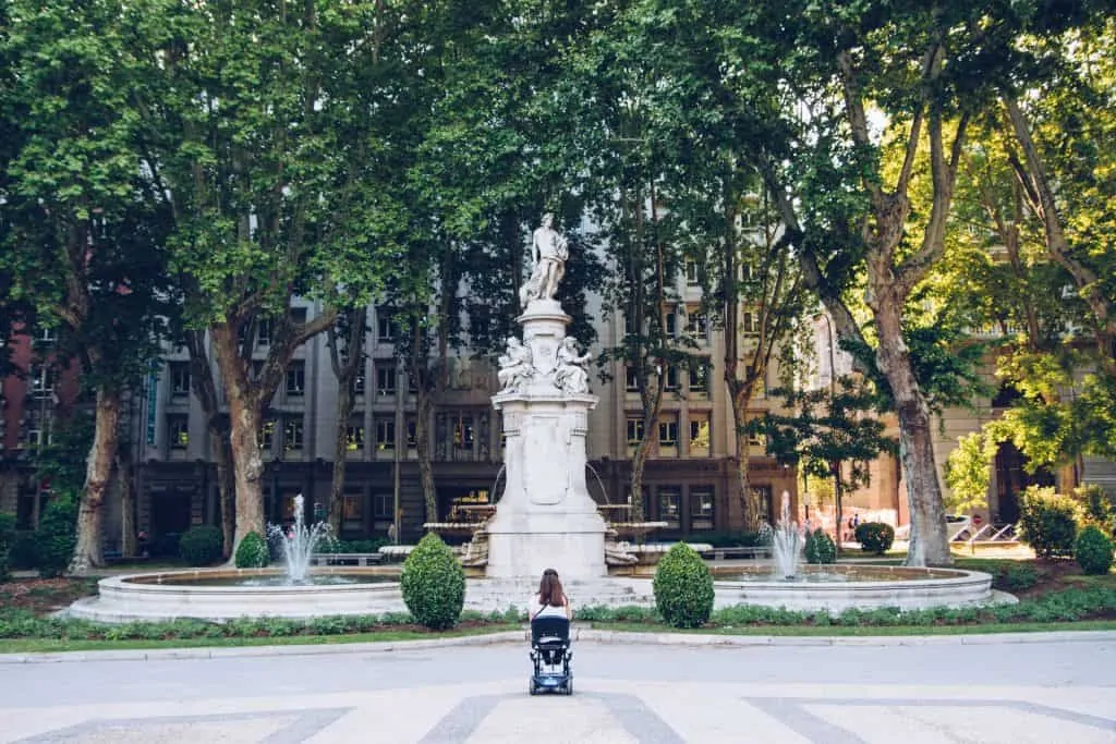 woman in wheelchair in front of a fountain reflecting disability: MS or multiple sclerosis