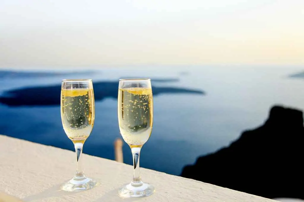 2 glasses of champage on a balcony overlooking the sea