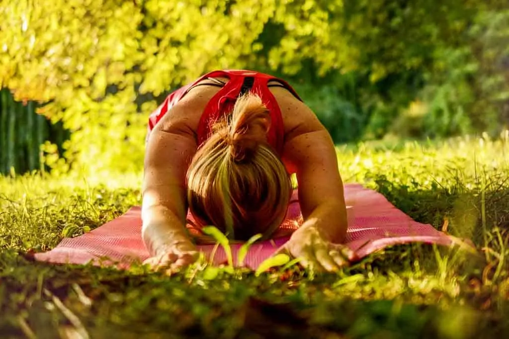 woman doing yoga in a grassy green environment:Coimbra vitamin D protocol