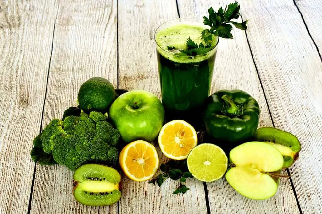 photo of green smoothie surrounded by green fruit and vegetables