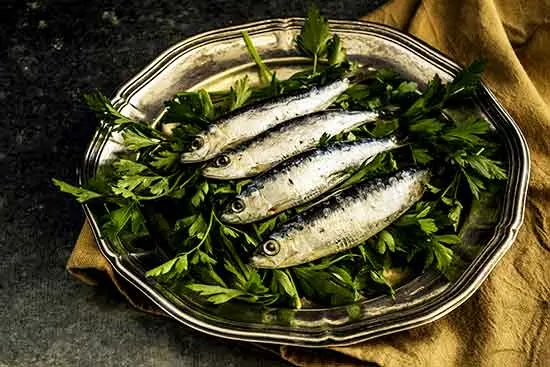 photo of sardines on a tray with parsley