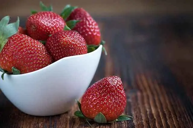 photo of a small white bowl with strawberries in it.