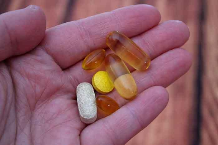 photo of a hand holding vitamins and supplements - Coimbra vitamins - best choices